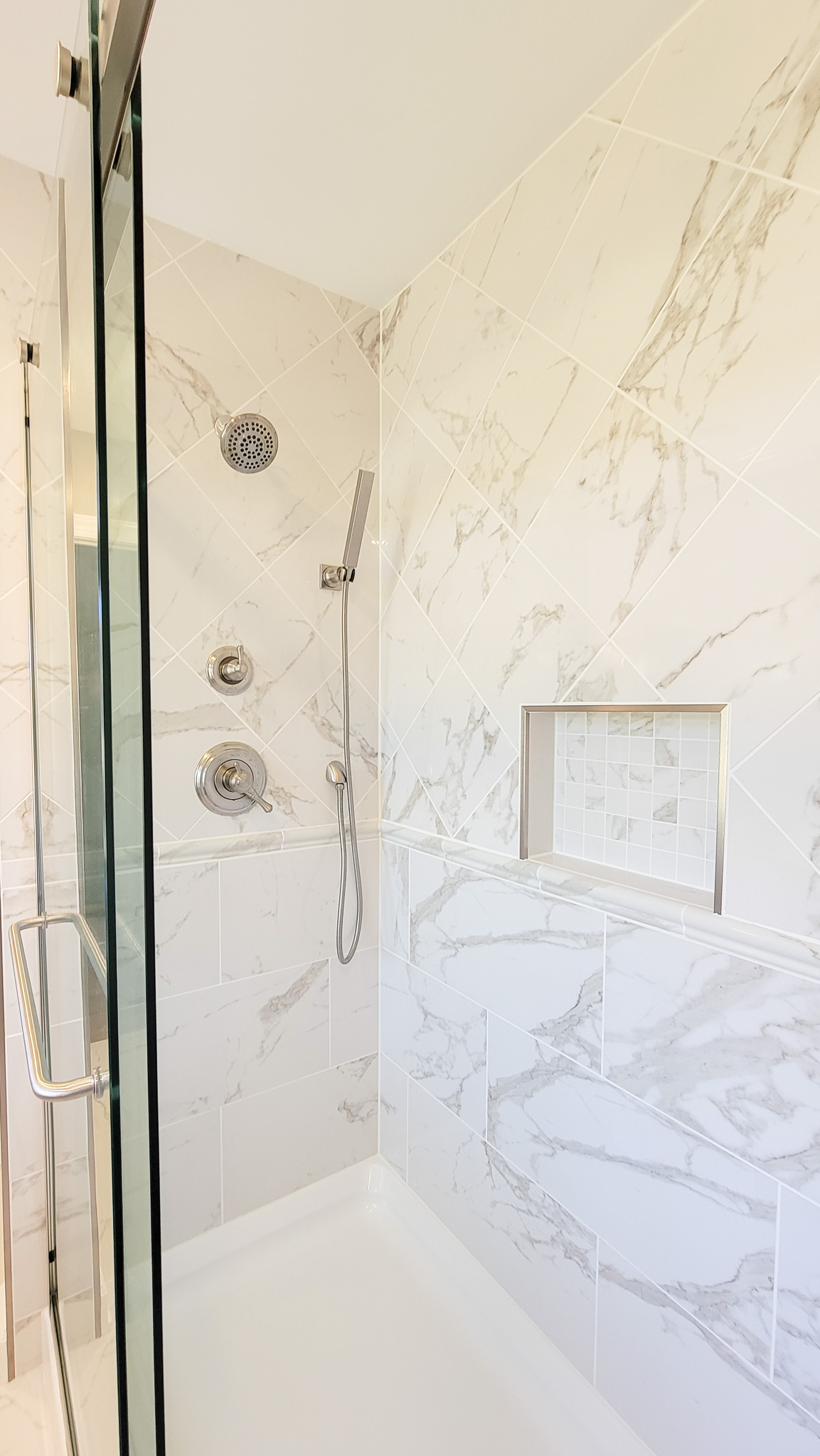 Klimovich bathroom remodel shower that features custom shampoo niche.