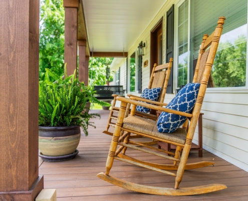 Two rocking chairs with blue pillows next to each other on a porch in Grottoes, VA.